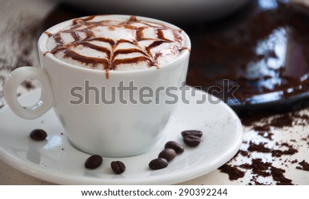 White cup of latte art coffee with coffee counter coffee background