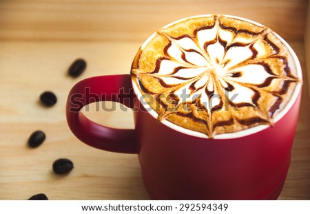 A latte art in red coffee cup with seeds coffee