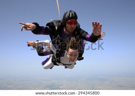 Skydiving. Girl falling in free fall and observing the earth.
