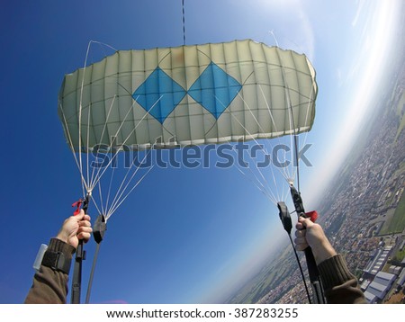 Point of view of skydiver piloting his parachute. Fish eye lens used. Sunshine right image .