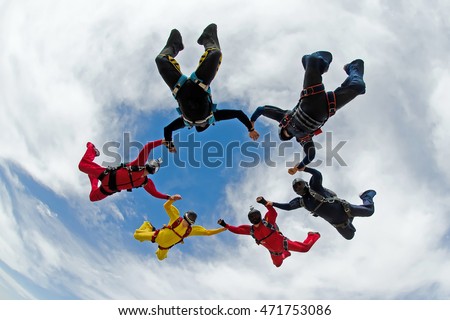 Skydiving holding hands friends