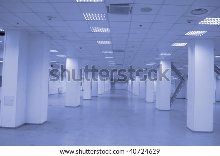 Empty warehouse equipped with lighting and ventilation.