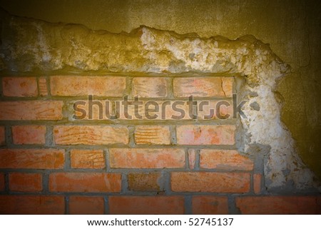 Ancient brick wall with cracks and the fallen off plaster