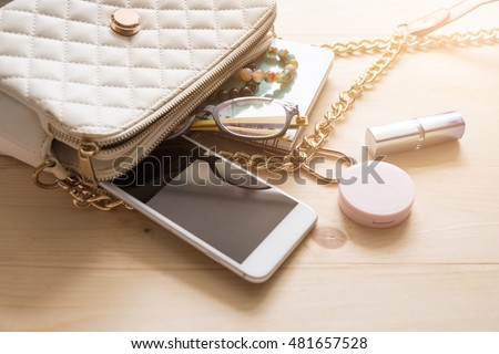 Top view of Women bag and lady stuff with copyspace on wooden background, vigtage effect photo