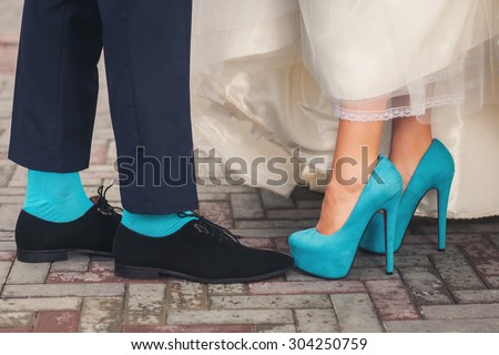 Funny colorful wedding shoes and socks on people legs