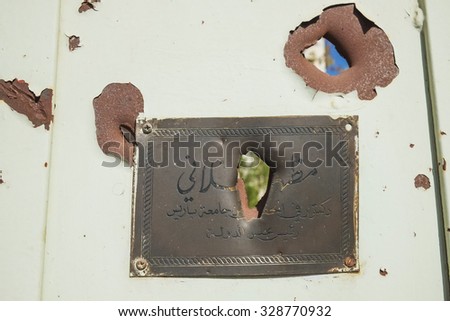 SYRIA, SHABAA, SEPTEMBER 2013. Bullet plaque with the inscription on the gate of an apartment house in the suburbs of Damascus, Shabaa.