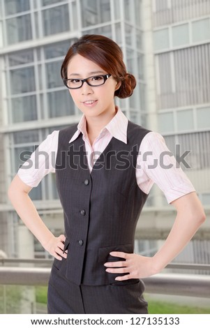 Confident business woman stand in outside of office and look at you.