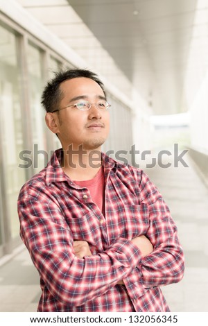 Asian man with glasses stand at street, closeup portrait.