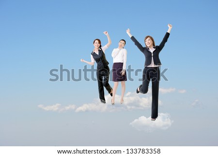 Cheerful three Asian business women stand on clouds and raise their arms feel freedom and exciting over blue sky.