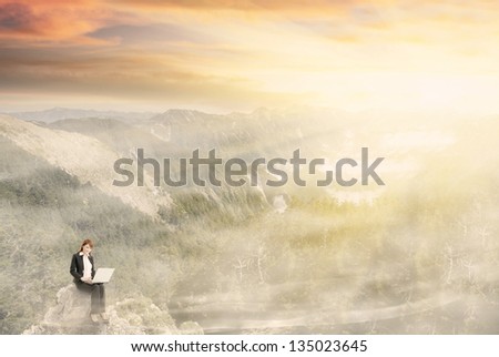 Business woman working at dream with beautiful misty mountain landscape under dramatic sunlight. Photo compilation concept about business, dream, freedom, relax, comfortable etc.