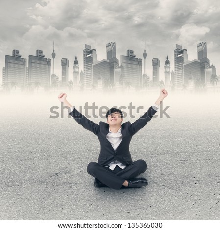 Asian business man sit on ground and open arms feel free and relax at modern city.