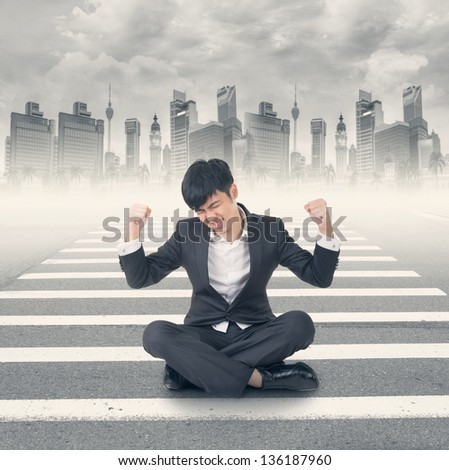 Young Asian businessman sit on ground and feel relax or struggle at modern city.