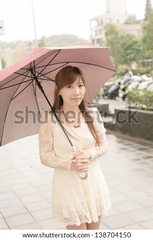 Asian beauty in raining day hold an umbrella in outside, Taipei, Taiwan.