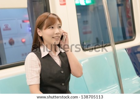 Portrait of young business woman commute and talk on phone inside of carriage in Taipei, Taiwan, Asia.