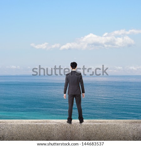 Asian business man stand and look the ocean under blue sky, concept of freedom, life, leisure, future etc.