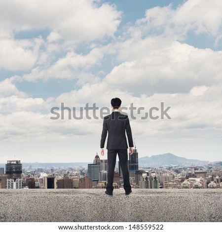 Asian business man stand and look the city under sky, concept of hard work, business, future etc.