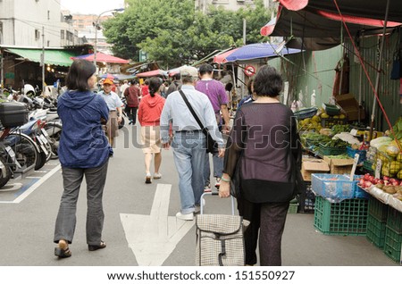 TAIPEI, TAIWAN - October 9 : A group of old people walk toward the traditional marketplace to shop on October 9, 2012 in Taipei, Taiwan, Asia.