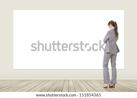 Asian elegant business woman standing and looking at blank white banner, board, placard or poster. Copy-space for advertise.