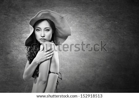 Attractive sexy asian lady in bikini with hat. Black and white photo.