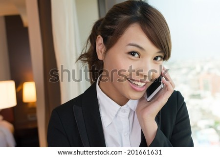 Asian young business woman using cellphone, closeup portrait in hotel.