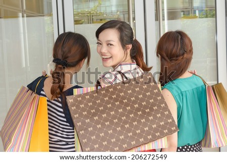 Group of Asian women shopping and holding shopping bags.