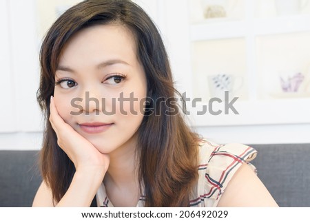 Elegant Asian woman thinking in a restaurant with copyspace.