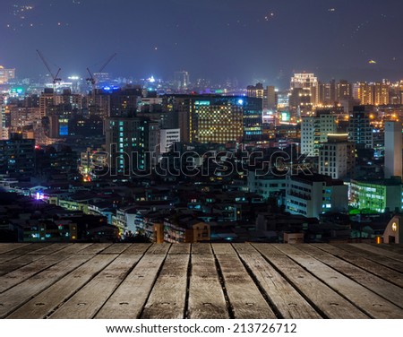 Colorful city night scene with modern skyscrapers, Taipei, Taiwan. Focus on wooden floor.