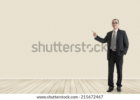 Asian business man introduce with empty wall in a room.