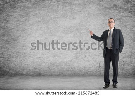 Asian business man introduce with empty wall in a room.