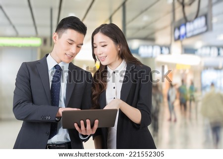 Business man and woman hold a tablet and discuss, closeup portrait with copyspace.