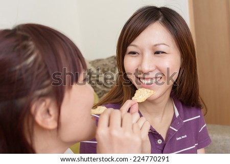 Party of lady, two women eating something in the living room.