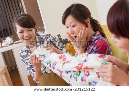 Beautiful young woman fight for the brand new clothes to her friend in the room.