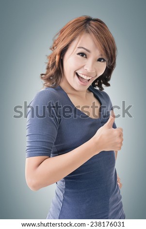Smiling Asian woman give you a thumb up gesture.