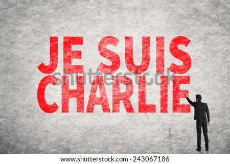 Asian businessman write text on wall, I am Charlie (In French)