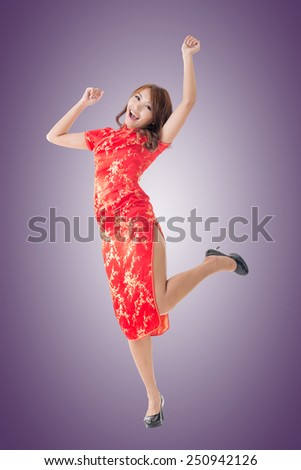 Smiling and excited Chinese woman dress traditional cheongsam at New Year, studio shot isolated.