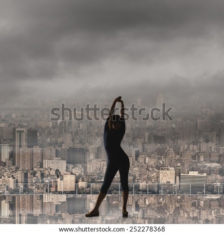 silhouette of Asian woman under heavy clouds in the city. concept of girl power, confident, freedom etc.