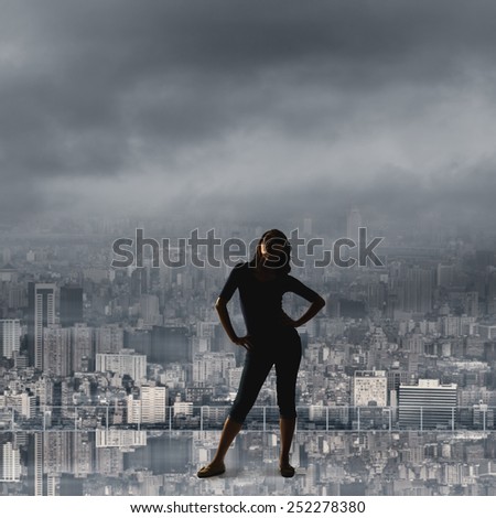 silhouette of Asian woman under heavy clouds in the city. concept of girl power, confident, freedom etc.