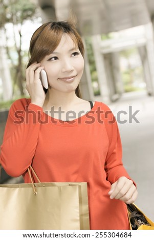 Smile shopping woman sit and use cellphone in Xinyi district, the business and commercial center in Taipei, Taiwan, Asia.