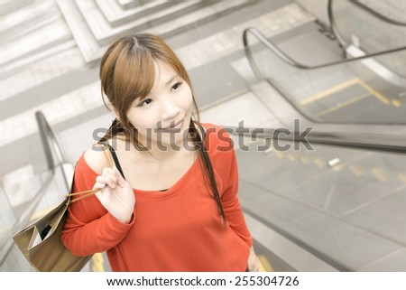 Smile shopping woman walk at escalate in Xinyi district, the business and commercial center in Taipei, Taiwan, Asia.