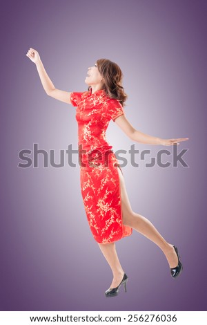 Smiling and excited Chinese woman dress traditional cheongsam at New Year, studio shot isolated.