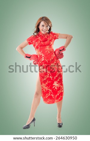 Chinese woman dress traditional cheongsam and boxing gloves, full length portrait isolated.