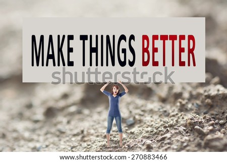Make things better, words on blank board hold by a young girl in the outdoor.