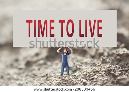 Time to live, words on blank board hold by a young girl in the outdoor.