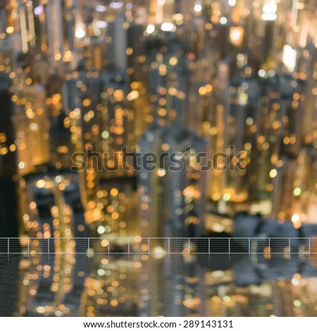 Background of blurred skyscrapers at night with reflection on the roof of building in Hong Kong, shallow depth of focus.