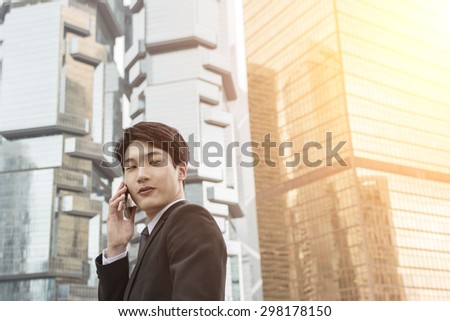 Confident young Asian businessman using cellphone, concept of business, technology, social media etc.