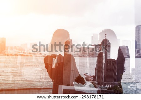 Silhouette of two businesswomen stand and look far away in Hong Kong, Asia. Double exposure.