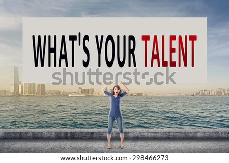 What\'s your talent, words on blank board hold by a young girl in the outdoor.