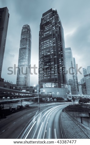 Skyscraper with traffic motion blurred lights in the night in Hong Kong, Asia.