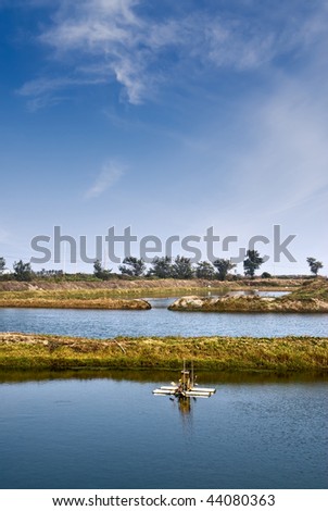 Fish pond scenic with water wheel in countryside.