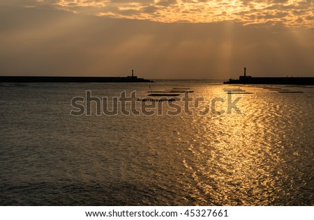 Sunset of ocean with boat and tower.
